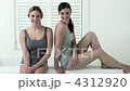 Two young women sitting on edge of bathtub 4312920