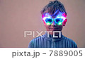 Young boy in glasses with colourful illumination smiles near wall, closeup view 7889005