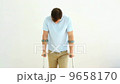 Injured man on crutches stepping towards camera 9658170