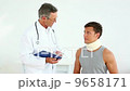 Sportsman in neck brace talking to doctor 9658171