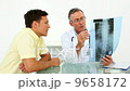 Doctor showing spine xray to his patient 9658172