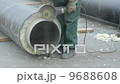 Worker cutting pipe with grinder 9688608