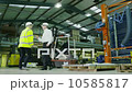 Team of busy warehouse workers lifting and moving empty pallets and boxes 10585817