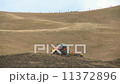 A tractor ploughes a hillside on a farm 11372896