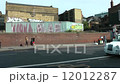 Street scene in East end of London with brick wall  and graffiti on steel cladding of building 12012287