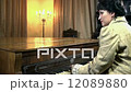 Female in romanesque garment playing piano shot from the back 12089880