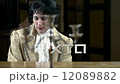 Woman in golden dress playing piano vivaciously 12089882