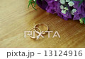 Wedding bouquet and golden rings on seesaw 13124916