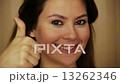 Young woman smiling with thumbs up 13262346