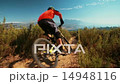 High angle view of mountain biker riding a dirt path downhill 14948116