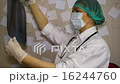 Young doctor wearing a mask examines an x-ray  16244760