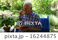 An elderly man sitting and reading a book  16244875