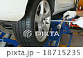 mechanic hands replace car tire on jack in garage 18715235