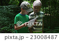 Geocaching - a Boy and a Girl Reading a Sheet of 23008487