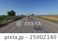 A woman riding a bike on a country road. 25002140