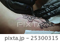 Tattoo Artist Does the Tattoo on a Woman's Hand. 25300315