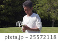 操作有草坪的一名資深男性一個智能手機在刷新的陽光公園 25572118
