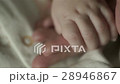 A charming baby is holding mother's finger. Mom 28946867