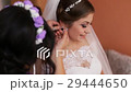 Bridesmaid helping bride to dress up before 29444650