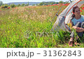 Women in tent in flower field looking far away 31362843
