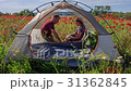Man and woman drink near tent among flowers 31362845