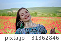Woman among poppy flowers smiles at camera 31362846