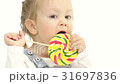 Little girl is holding a sweet candy in her hands 31697836