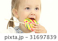 Child is holding a sweet candy in her hands and 31697839