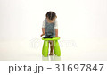 Child near a green highchair and holds a laptop 31697847