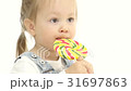 Baby is holding a sweet candy in her hands and 31697863