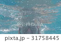 Happy boy swims underwater in swimming pool with 31758445