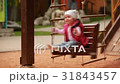 Adorable baby girl enjoying a swing ride on a 31843457