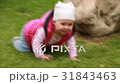 Cute smiling baby-girl crawling on a green grass 31843463