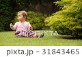 Beautiful happy little baby girl sitting on a 31843465