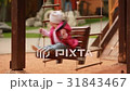 Adorable baby girl enjoying a swing ride on a 31843467