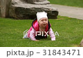 Cute smiling baby-girl crawling on a green grass 31843471