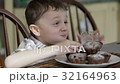 Little boy eating cake at home 32164963