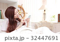 A woman who plays a smartphone in bedroom 32447691