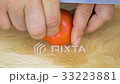 slicing tomato on cutting board 33223881