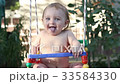 Smiling baby riding on a swing and laughing 33584330