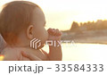 Smiling baby creeps on the pier at sunset 33584333