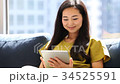 A woman watching a tablet at the window side 34525591