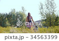 A young woman, on a summer sunny day, walks 34563399