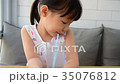 girl drinking water from glass with straw  35076812