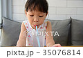 girl drinking water from glass with straw  35076814