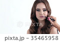 Makeup artist making makeup for a beautiful girl.  35465958