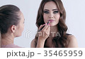 Makeup artist making makeup for a beautiful girl.  35465959