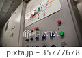Factory Worker is Setting Up CNC Lathe Machine in 35777678