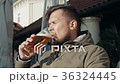 Young Man Drinking Glass of Beer In a Street 36324445
