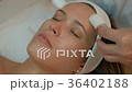 Skilled beautician makes face massage with tassels Skilled beautician makes face massage with tassels 36402188